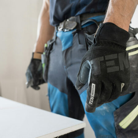 Handwerker bei Reparaturarbeiten mit Schutzhandschuhen und Werkzeug.