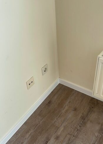 Professionell verlegter Laminatboden mit sauberem Abschluss an der Wand.