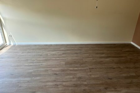 Übersicht eines Raumes mit neuem, professionell verlegtem Laminatboden.